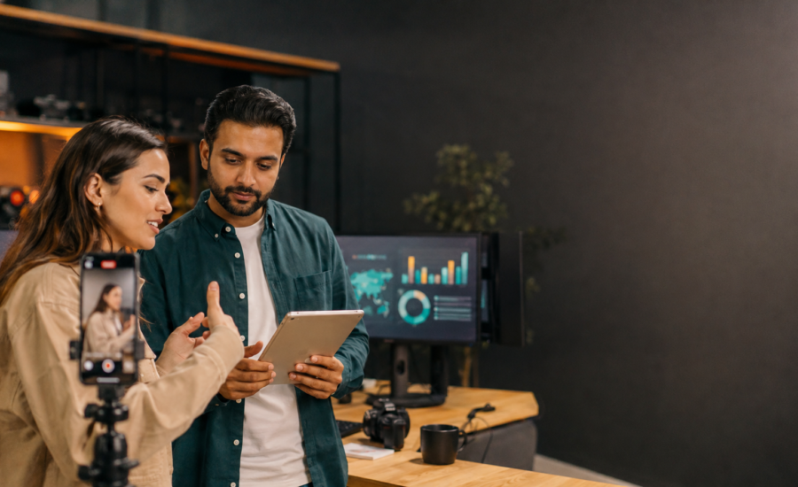 UK and UAE producer reviewing creator video performance metrics in a content studio
