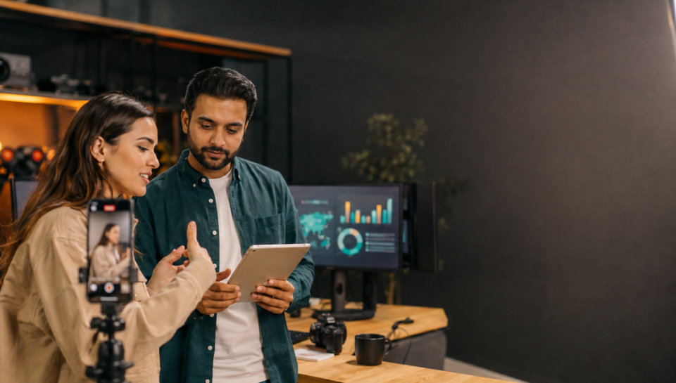 UK and UAE producer reviewing creator video performance metrics in a content studio