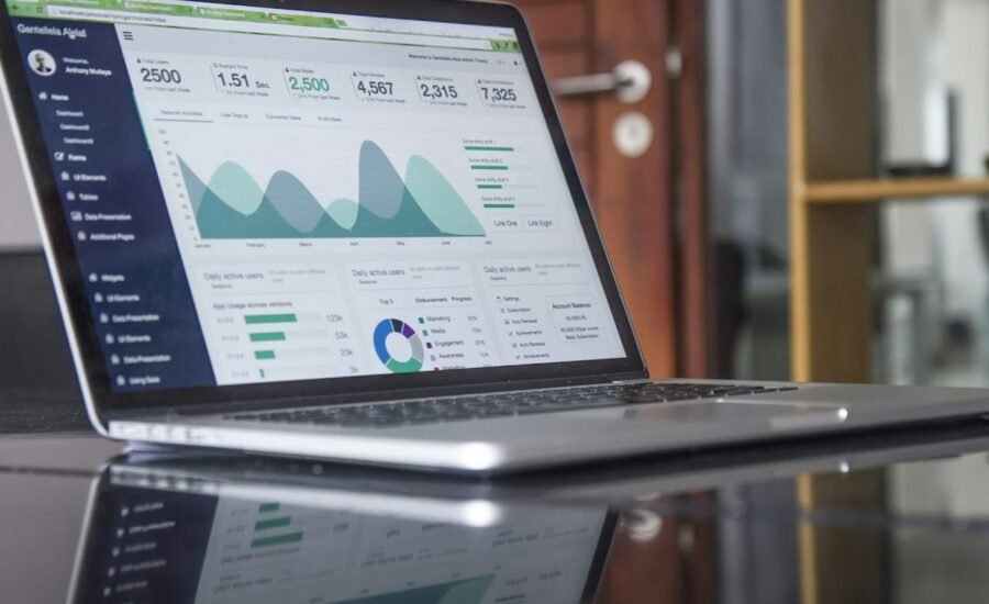 Business professional reviewing charts and documents on a laptop, representing AI quote and estimating automation