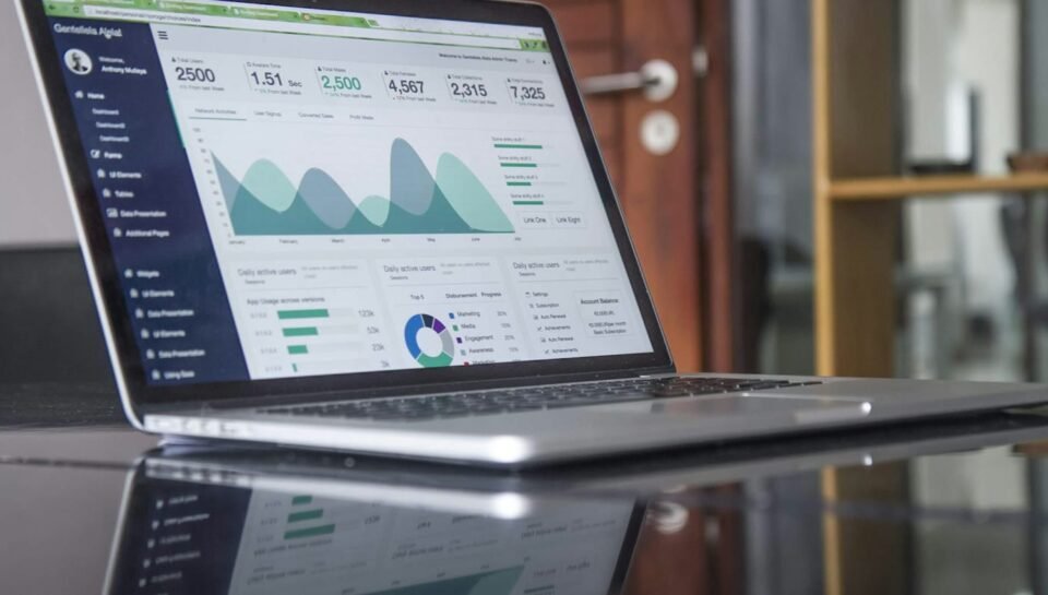 Business professional reviewing charts and documents on a laptop, representing AI quote and estimating automation