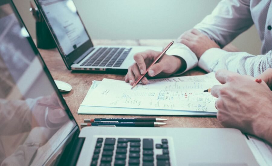 Professionals reviewing documents and charts at a desk, representing AI-assisted RFP and proposal response workflows