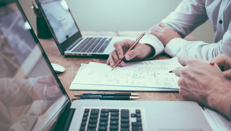 Professionals reviewing documents and charts at a desk, representing AI-assisted RFP and proposal response workflows