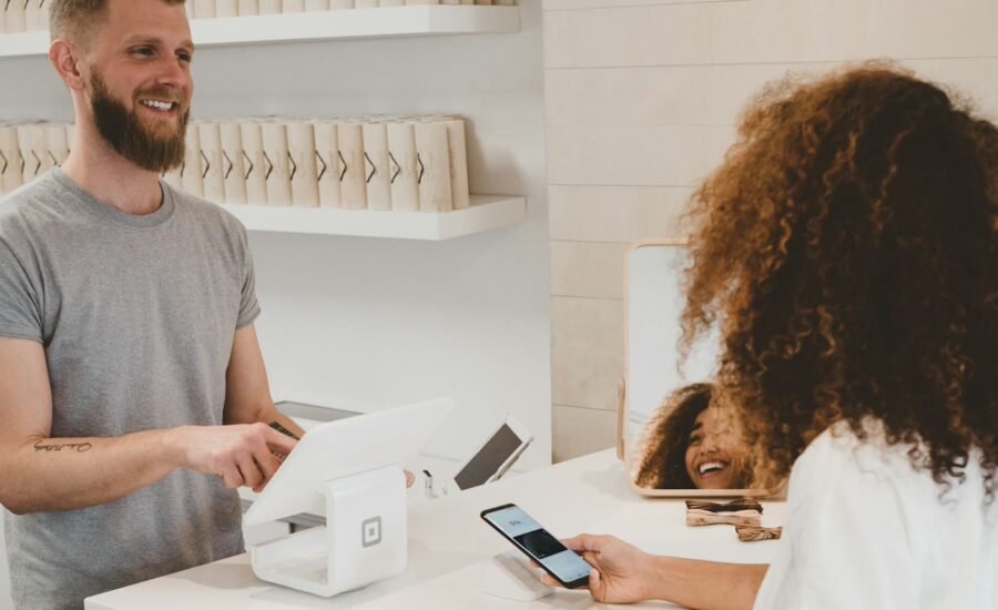Customer completing a card payment at a counter, representing booking and Stripe payments automation into CRM