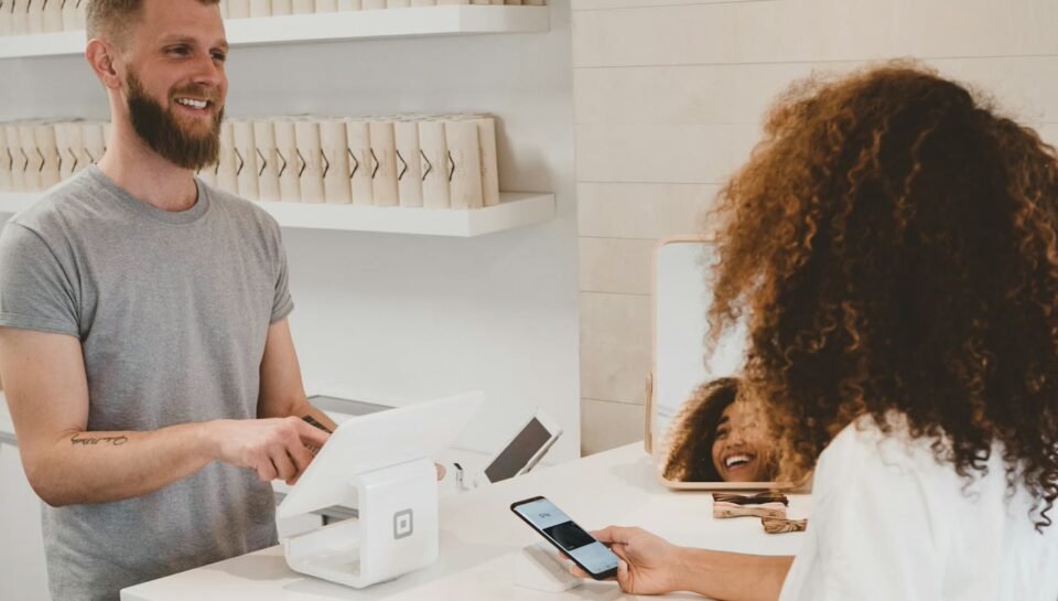 Customer completing a card payment at a counter, representing booking and Stripe payments automation into CRM