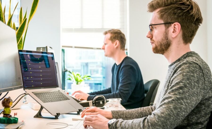 Team collaborating at computers building a bilingual website chatbot experience in a bright office