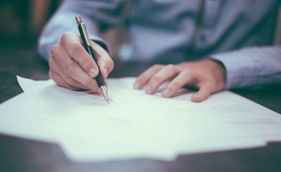 Professional reviewing and signing business documents at a desk, representing AI-assisted contract review and NDA redlining