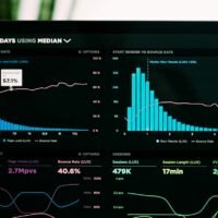 Analytics dashboard and workflow charts on a laptop screen, representing AI agent orchestration with n8n, Make and Zapier